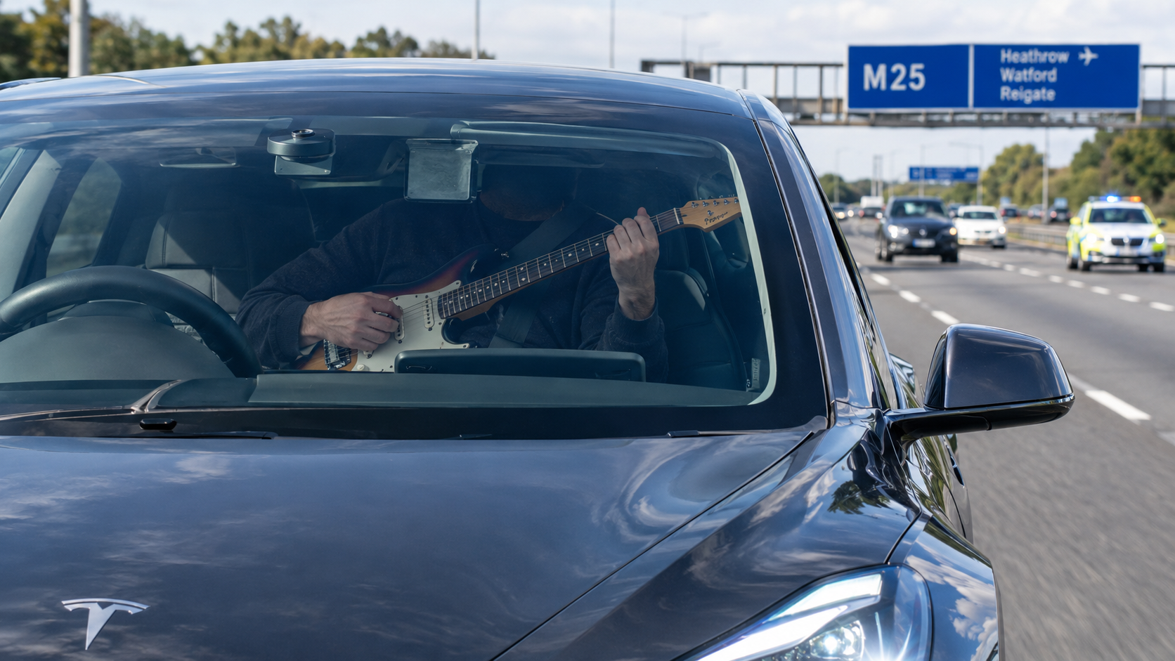 Una Tesla sulla M25, una chitarra in mano e 60 mph sul tachimetro: la polizia ha fermato il conducente e trovato un dispositivo sul volante.